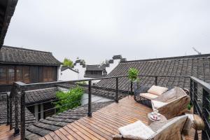 DongpuにあるHuazhu Luxury Lotus Twilight Fossil Museum B&Bの椅子付きの木製デッキのあるバルコニー