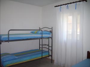 a room with two bunk beds and a window at Villino Dodò in Torre San Giovanni Ugento +8 photos