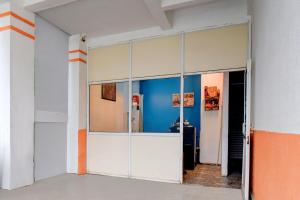 een grote glazen deur in een kamer met een blauwe muur bij Hotel O Hinjewadi Kirti Classic Gate in Pune