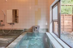 uma banheira em um banheiro com janela em Noël Hakone Chimney em Hakone mais 52 fotografias