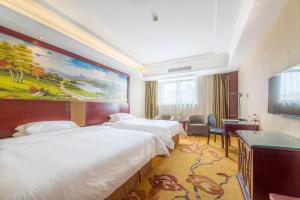 a hotel room with two beds and a flat screen tv at Vienna Shanghai Chongming Changxing Island in Dongxing +221 photos