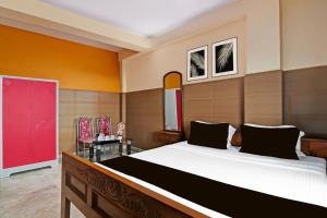 a bedroom with a large bed in a room at Super Hotel O Rishra Railway Station Formerly Green Guest House in Khardah