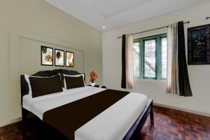 a bedroom with a large bed and a window at Super Collection O Chalakkudy River Annamanada Formerly Svasthya Retreat in Māla +31 photos