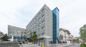 a large building on a city street with buildings at Xana Hotelle·JiNan Daminghu East Gate Shandong University in Jinan