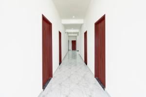 an empty corridor with two doors and a tile floor at Super Hotel O Mehta College And Institute Of Technology Formerly Lara Heritage in Jaipur