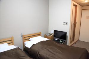 Postel nebo postele na pokoji v ubytování Hotel New Kotobuki