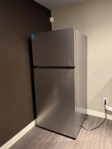 埃德蒙顿2-Room Suite in South Edmonton的一间房间的角落里的一个不锈钢冰箱 更多6张照片
