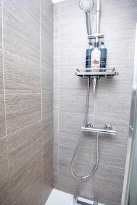 une salle de bain avec une douche avec pommeau de douche dans l'établissement PG Stays - Spacious Rooms with Shared Facilities, à Wigan 39 autres photos