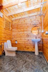 a wooden bathroom with a toilet and a sink at Ourem Palace in Palolem