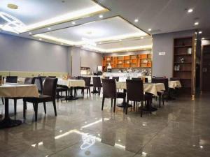 een restaurant met tafels en stoelen in een kamer bij Vienna Hotel Tongliao Ke'erqin in Tongliao