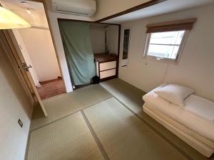 En eller flere senge i et værelse på 佐藤理容Inn