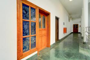 a hallway with a wooden door with glass windows at Super Collection O Kangarappady Formerly Cochin Residency in Kakkanad +23 photos