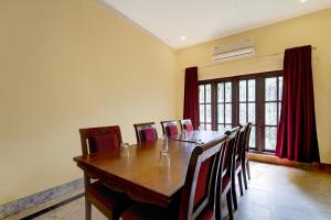 a dining room with a wooden table and chairs at Super Collection O Kangarappady Formerly Cochin Residency in Kakkanad