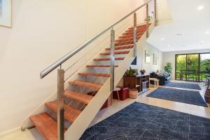 a staircase in a living room with blue rugs at 4A Wood St-PetsNegotiable Linen Included Wi-Fi - Linen Included in Kilki