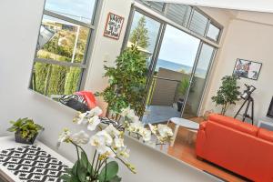 a living room with a red couch and large windows at 4A Wood St-PetsNegotiable Linen Included Wi-Fi - Linen Included in Kilki