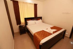 une chambre avec un lit avec un arc dessus dans l'établissement Karuna Regent, à Chennai