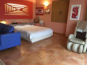 a bedroom with a bed and a couch and a chair at Hotel Fantacy (Adult Only) in Hamamatsu