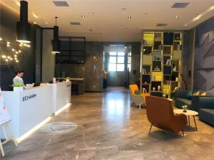 een vrouw aan een balie in een lobby bij Echarm Hotel An'xi Hengxing Coach Station in Anxi