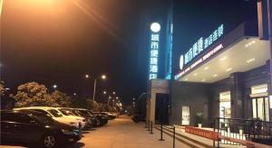 een parkeerplaats met auto's geparkeerd voor een gebouw bij City Comfort Inn Yingcheng Railway Station Shanghe Square in Yingcheng