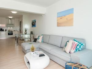 a living room with a couch and a table at Bungalow Playa del Inglés JFGI by VillaGranCanaria in Playa del Ingles