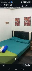 a bedroom with a bed with a blue bedsheet and avertisement at CZ HOTEL in Pasir Puteh