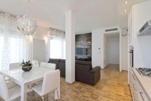 a kitchen and living room with a white table and a couch at Attico Stema Luxury in Misano Adriatico