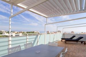 米薩諾阿德里亞蒂科的住宿－Attico Stema Luxury，阳台的天井配有桌椅