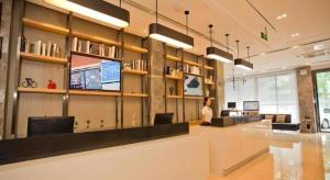 a woman in a library with a person sitting at a desk at City Comfort Inn Deyang Wenmiao Square Gymnasium in Deyang