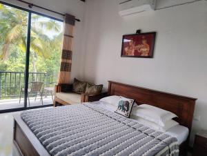 een slaapkamer met een bed met uitzicht op een balkon bij Hanthana view in Peradeniya
