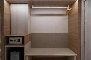 a walk in closet with a bench and a microwave at Bluphere Residence by Prop Hopper in Na Jomtien