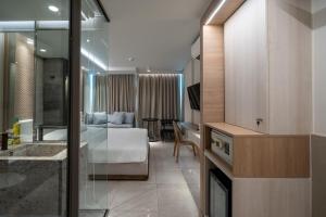 ein Hotelzimmer mit Bett und Schreibtisch in der Unterkunft Bluphere Residence by Prop Hopper in Na Jomtien