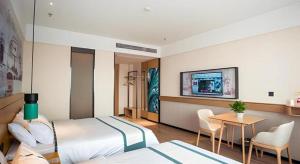 a hotel room with two beds and a flat screen tv at City Comfort Inn Suzhou Zhangjiagang Jingang Changjiang Xi Road in Xiwujieqiao +99 photos