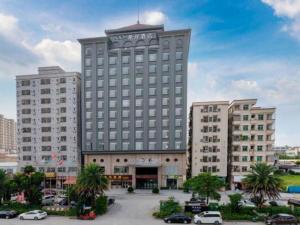een groot gebouw met een bord erop bij Xana Hotelle· Dongguang Chang'An Binhaiwan Jian'An Road in Hongmei