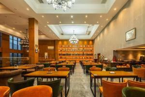 een restaurant met tafels en stoelen en een bar bij James Joyce Coffetel· Changde Liuyehu in Changde