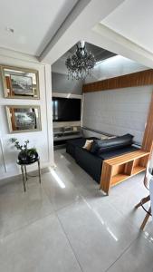 un soggiorno con un divano nero e un tavolo di Charmant Vertigo a Campo Grande