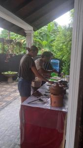 a group of people preparing food at a table at Indunil Family Residence With Pool Hiriketiya in Dickwella