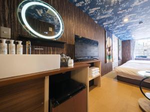 a bathroom with a sink and a bed in a room at Tomaru House J in Chiba