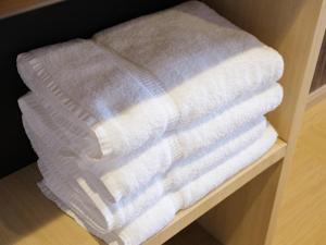 a stack of towels sitting on a shelf at 泊るHouse千葉駅1分 J - 東京ディズニーランドまで30分 線路傍騒音あり in Chiba +99 photos