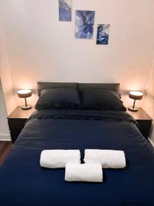 a bedroom with a blue bed with two towels on it at Fitaa House Southampton in Southampton