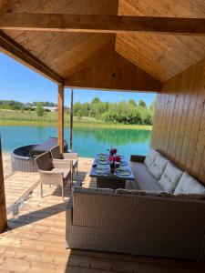 een terras met een bank en een tafel aan een meer bij Pas Milėją 