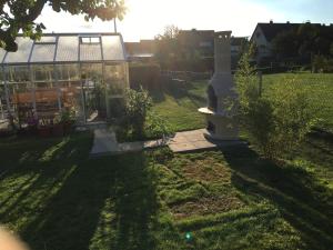un jardín con invernadero de cristal y césped en Pension Hugo, en Landwehrhagen