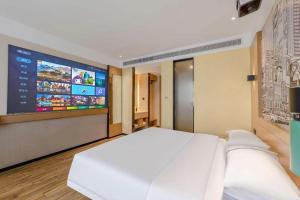 a bedroom with a white bed and a large screen at City Comfort Inn Quanzhou Wanda in Quanzhou