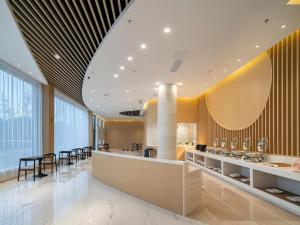 a lobby with a bar with tables and chairs at Deep Sleep Hotel Xuzhou High-Speed Railway Station East Square Oubeisha in Xuzhou