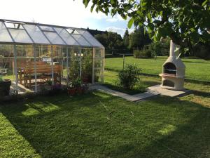 ein Gewächshaus in einem Garten mit einem Tisch und einer Bank in der Unterkunft Pension Hugo in Landwehrhagen