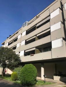 a white apartment building with bushes in front of it at Suite Piero della Francesca in Prato