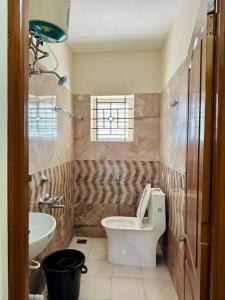 a bathroom with a toilet and a sink at Marvee Luxus Stay in Coimbatore