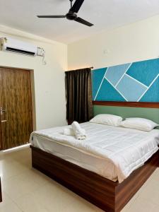 a bedroom with a bed with a painting on the wall at Marvee Luxus Stay in Coimbatore