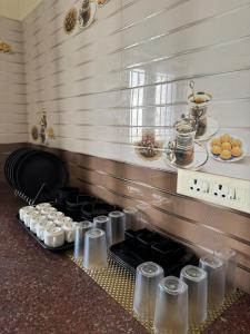 a kitchen with a stove with a bunch of cups at Marvee Luxus Stay in Coimbatore