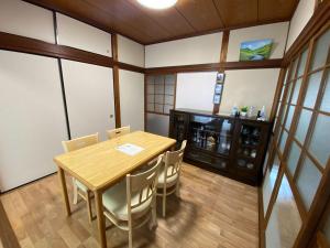 ein Esszimmer mit einem Holztisch und Stühlen in der Unterkunft あかり庵 in Iki