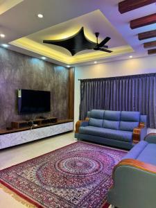 a living room with a couch and a tv at Marvee Luxus Stay in Coimbatore +83 photos